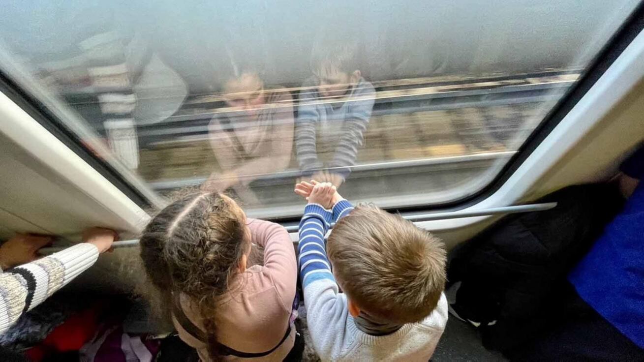 image:Image Ukrajinské děti na cestě do bezpečí vlakem z polského Přemyšle do Berlína. Jedenáctiletá Sofia se v chodbičce baví s osmiletým Mironem: „Ještě nikdy jsem nebyla v cizí zemi, ale dneska jsme projeli Polsko a Německo a pak pojedeme do Dánska. A nikdy jsem si nemyslela, že budu mluvit anglicky – a dneska překládám mamince.“
