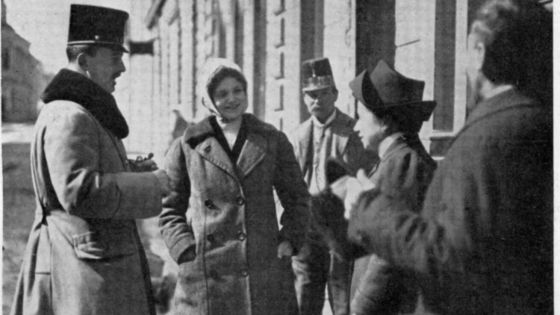 image:Image Zita a Karel v Brandýse nad Labem vyzvídají novinky od poštovní úřednice Jindřišky Byšické. Hovoru přihlíží obecní posluha pan Gelbes. I poslední zřízenec v monarchii nosil podle tehdejšího zvyku stejnou čepici (důstojnickou) jako císař.