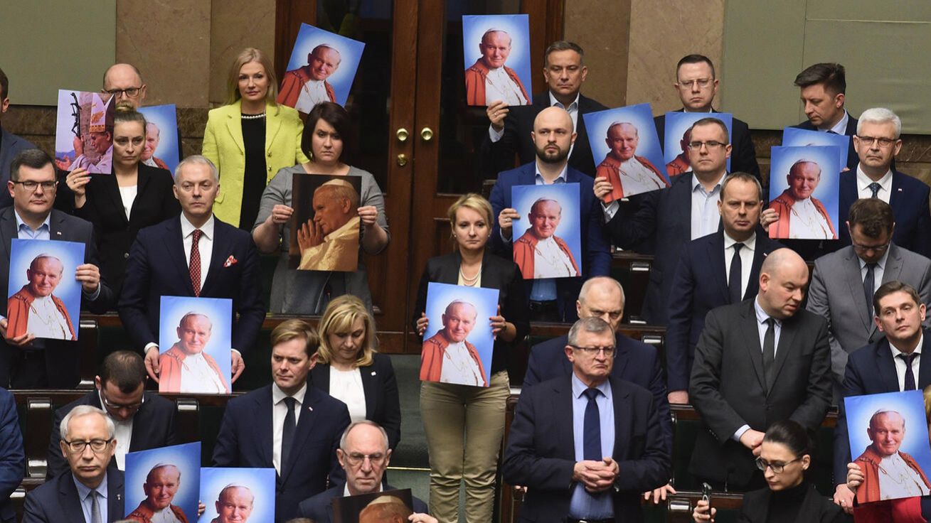 image:Image Portréty Jana Pavla II. přinesli do Sejmu někteří polští poslanci při projednávání rezoluce na obranu jeho dobrého jména, kterou předložili zákonodárci vládní strany Právo a spravedlnost.