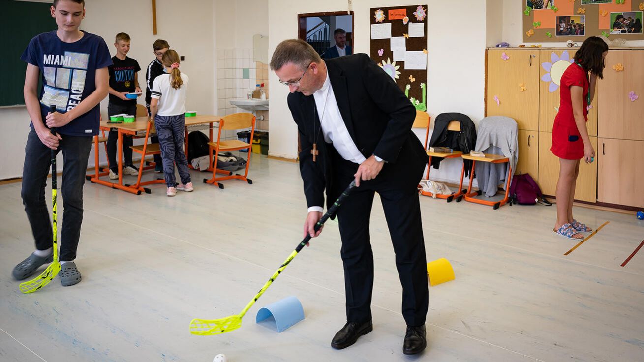 image:Image Biskup Martin David si zkouší při oslavách 30 let od vzniku biskupského gymnázia aktivitu pro děti, kterou studenti připravili pro návštěvníky.