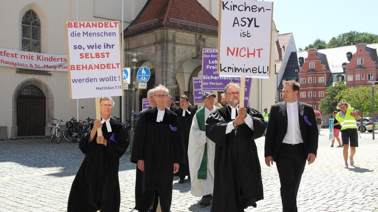 V bavorském Kemptenu podpořili věřící se svými duchovními z různých denominací starobylou praxi církevního azylu pochodem s transparenty. image:Image V bavorském Kemptenu podpořili věřící se svými duchovními z různých denominací starobylou praxi církevního azylu pochodem s transparenty.