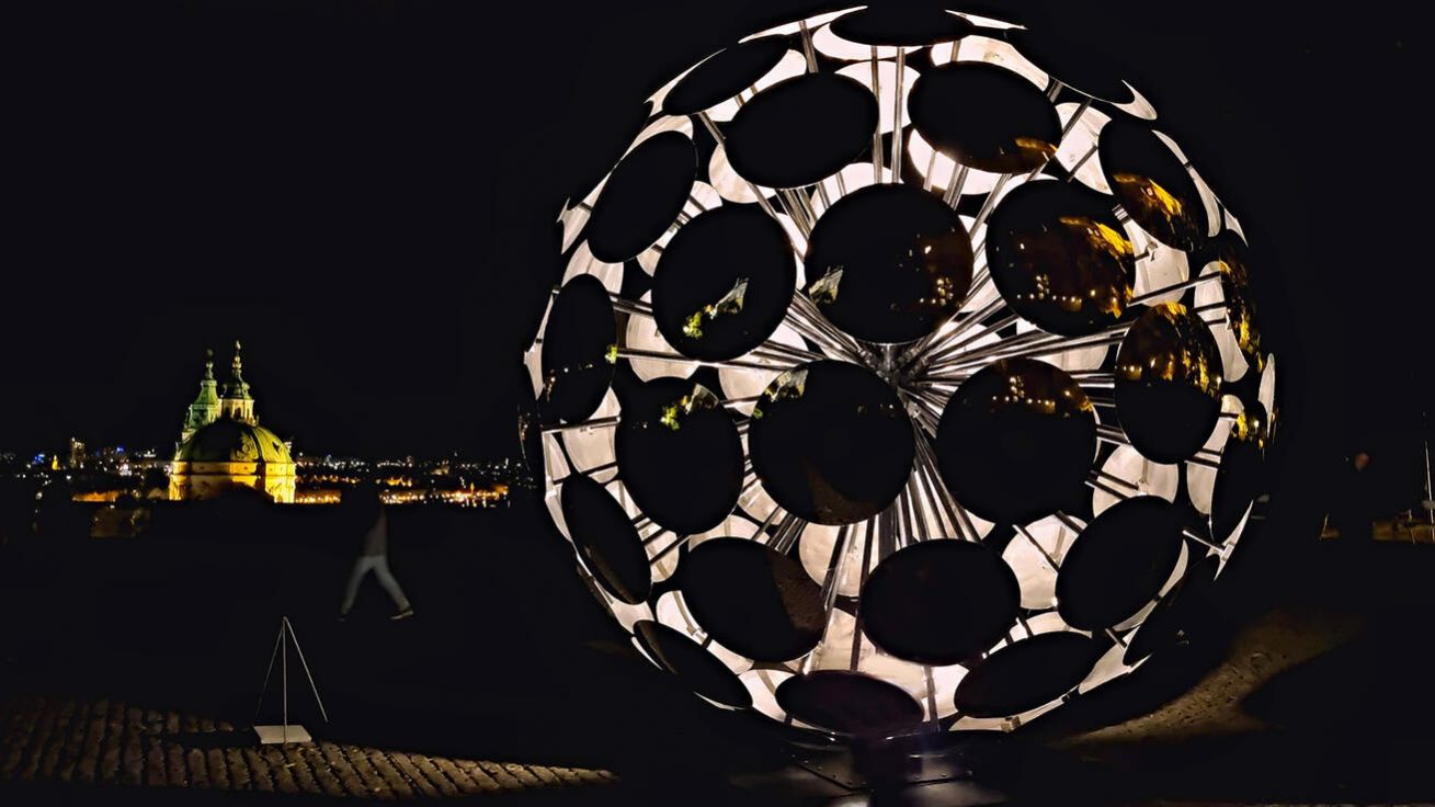 image:Image SIGNAL FESTIVAL rozzářil o víkendu v Praze i církevní stavby. Jedna z výrazných projekcí byla na Arcibiskupském paláci na Hradčanském náměstí. Byl to videomapping nazvaný Eternal Recurrence (Věčné opakování) vytvořený speciálně pro monumentální architekturu paláce. Tvůrci ho označili za digitální ságu o vzniku a vývoji forem života. Jen o pár kroků dál byla v Jižních zahradách Pražského hradu vidět kruhová instalace nazvaná ORB (na snímku, v pozadí chrám sv. Mikuláše). Vznikla již v roce 2022 jako součást velké výstavy „Forever Is Now II“, kterou pořádal Culturvator Art D’Égypte ve spolupráci s UNESCO a egyptským ministerstvem turismu a památek. Jeho první prezentace byla u pyramid v Gíze. Tvary a materiály objektu vycházejí z prvků matematiky a symboliky přítomné v klasické egyptské kultuře, a zejména právě v pyramidách. Jeho proporce odkazují na číslo „pí“ skryté v jejich geometrii.
