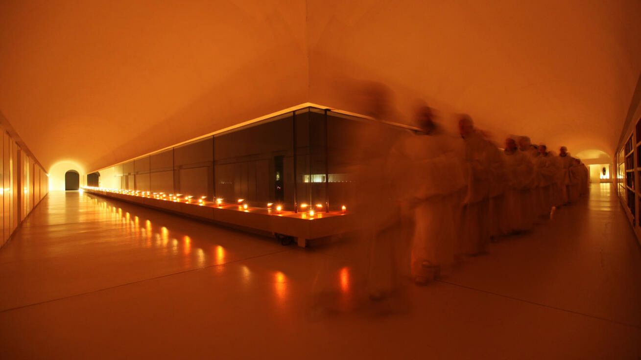 image:Image Procesí mnichů po večerních chválách před štědrovečerní večeří ve slavnostně nasvícené křížové chodbě novodvorského kláštera.