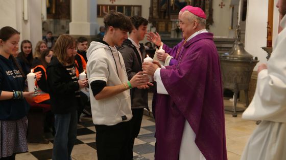 image:Image Zapálené svíce, které symbolizovaly modlitby na čtrnácti místech ve městě, přinesla mládež diecéznímu biskupovi jako obětní dar.