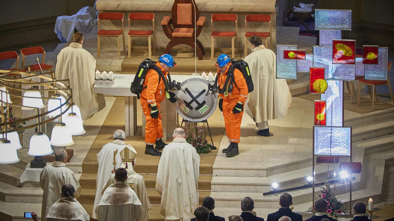 image:Image Báňstí záchranáři přinesli před oltář hrázový poklop s letopočty 1772 a 2026, které značí začátek a konec těžby v ostravsko-karvinské oblasti.