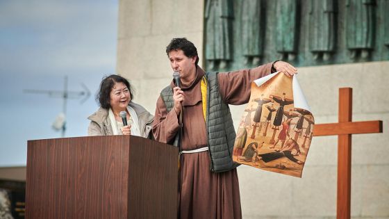 image:Image Provinciál českých františkánů Jakub Sadílek před památníkem 26 mučedníků z Nagasaki ukazuje vyobrazení jejich hromadného ukřižování v 16. století.