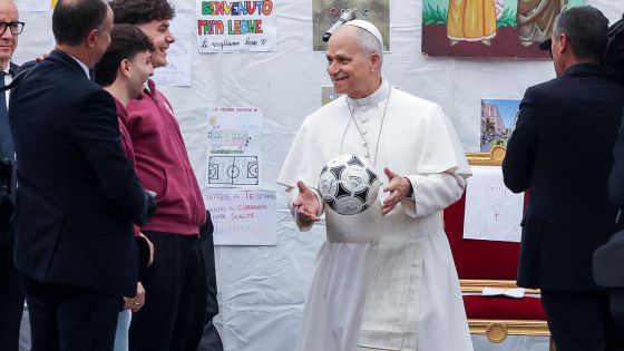 image:Image Papež s fotbalovým míčem v rukou si povídá s mladými lidmi při nedávné návštěvě ve farnosti Nanebevstoupení Páně na římském předměstí Quarticciolo.